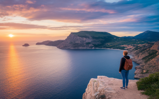 personne-sac-a-dos-falaise-mer-coucher-soleil