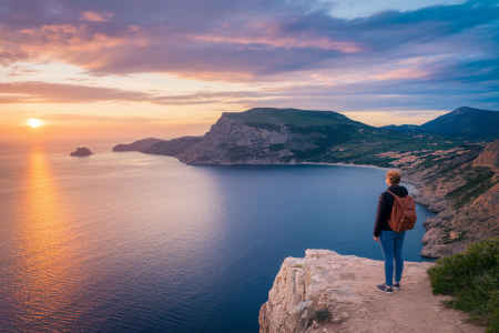 personne-sac-a-dos-falaise-mer-coucher-soleil